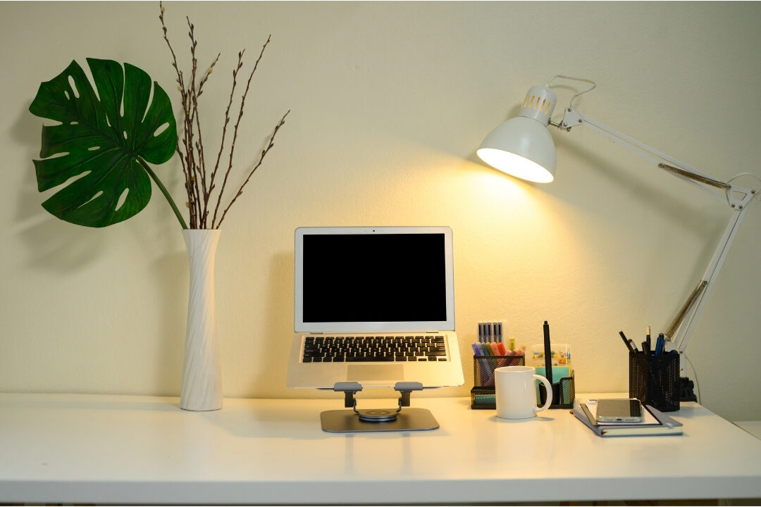 clean organized home office desk illuminated by warm lamp light demonstrating an effective shutdown routine