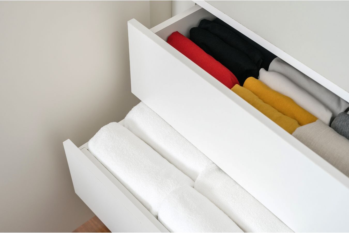 neatly folded clothes and paper notebook resting on wooden nightstand showing evening prep