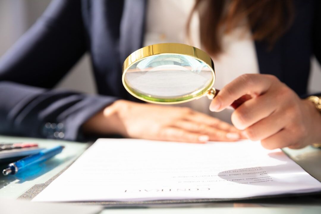 woman looking at a receipt with a magnifying glass reviewing retail add-on costs