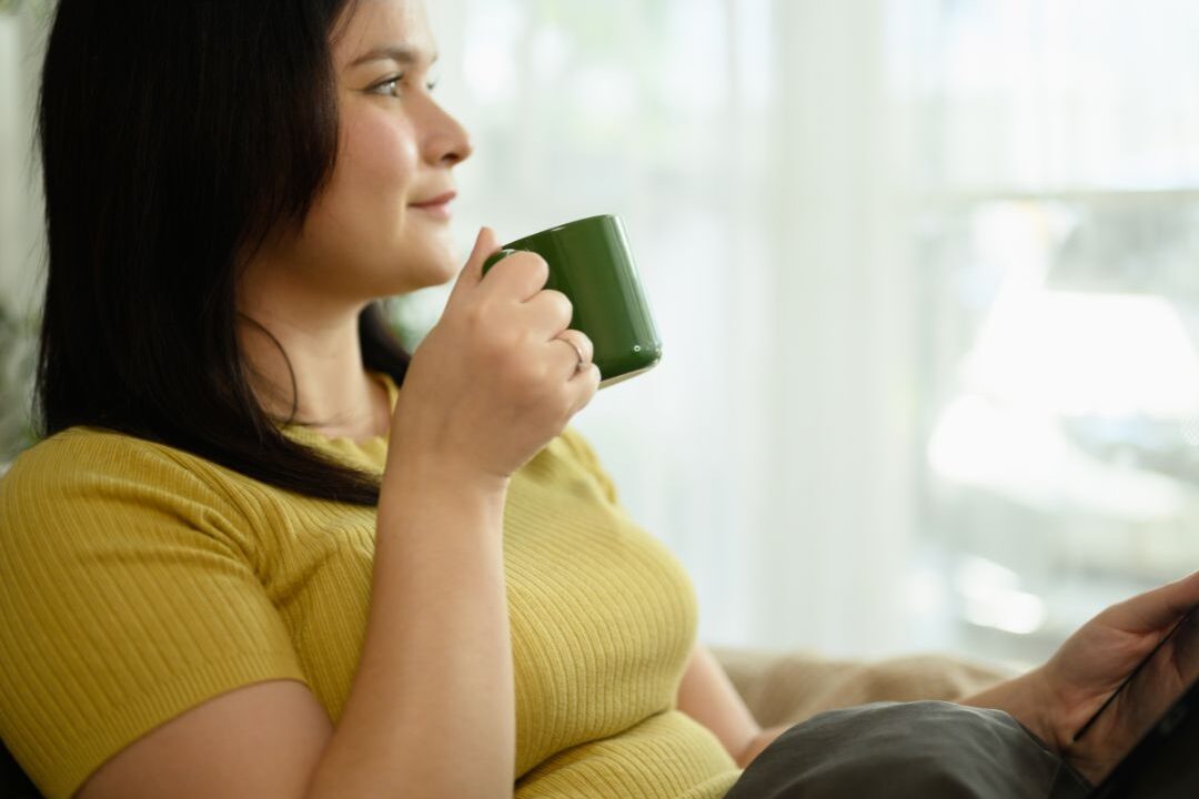 woman looking out a window thoughtfully working through the fear of public judgment