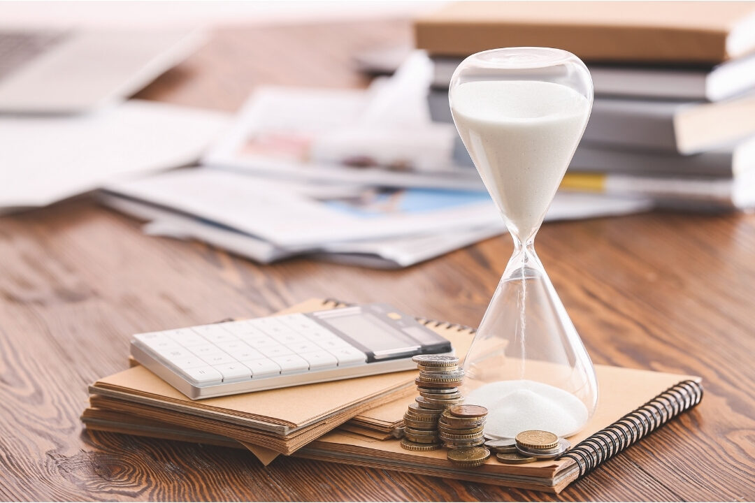 top down view of hourglass timer beside laptop and notebook on wooden desk organizing focused work windows
