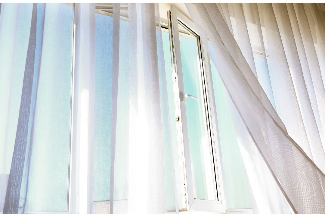 fresh air blowing through an open window with a green plant naturally refreshing the home