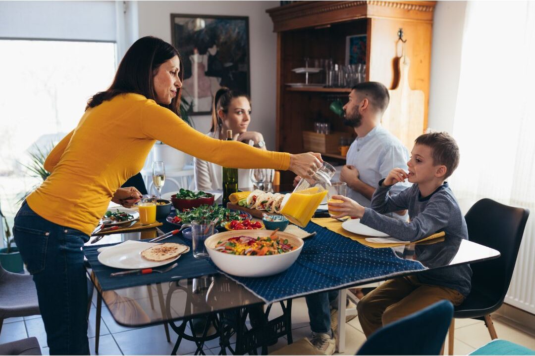 happy family eating dinner together at a dining table enjoying low cost delicious meals