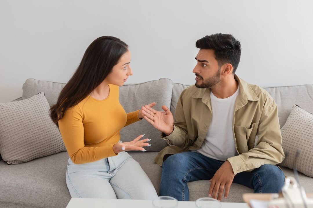 couple sitting on a sofa having a calm heartfelt conversation