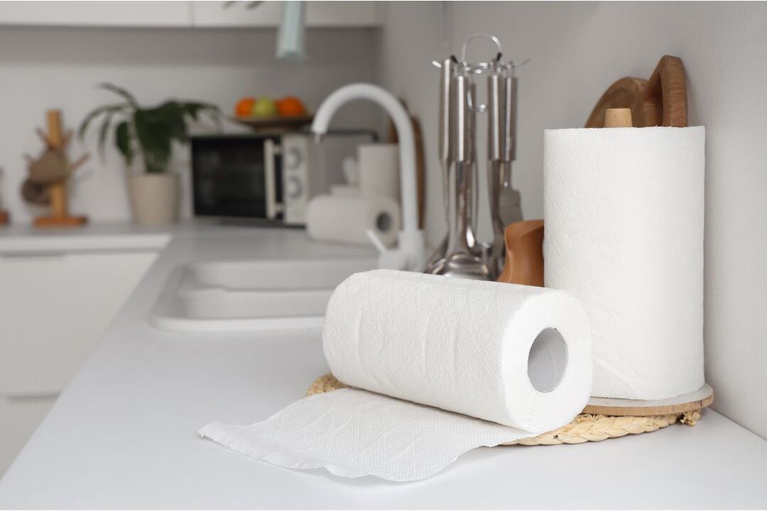 busy kitchen counter with paper towels and spray bottles showing common household spending traps