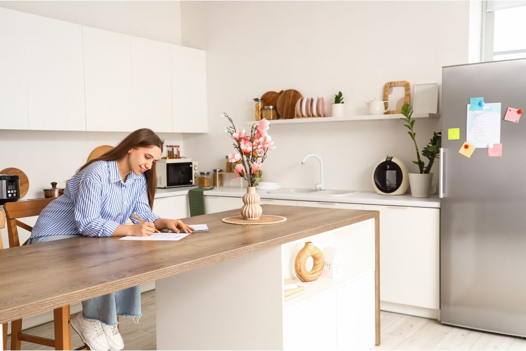 mother writing in planner at kitchen table with warm coffee showing things stay at home moms need to hear