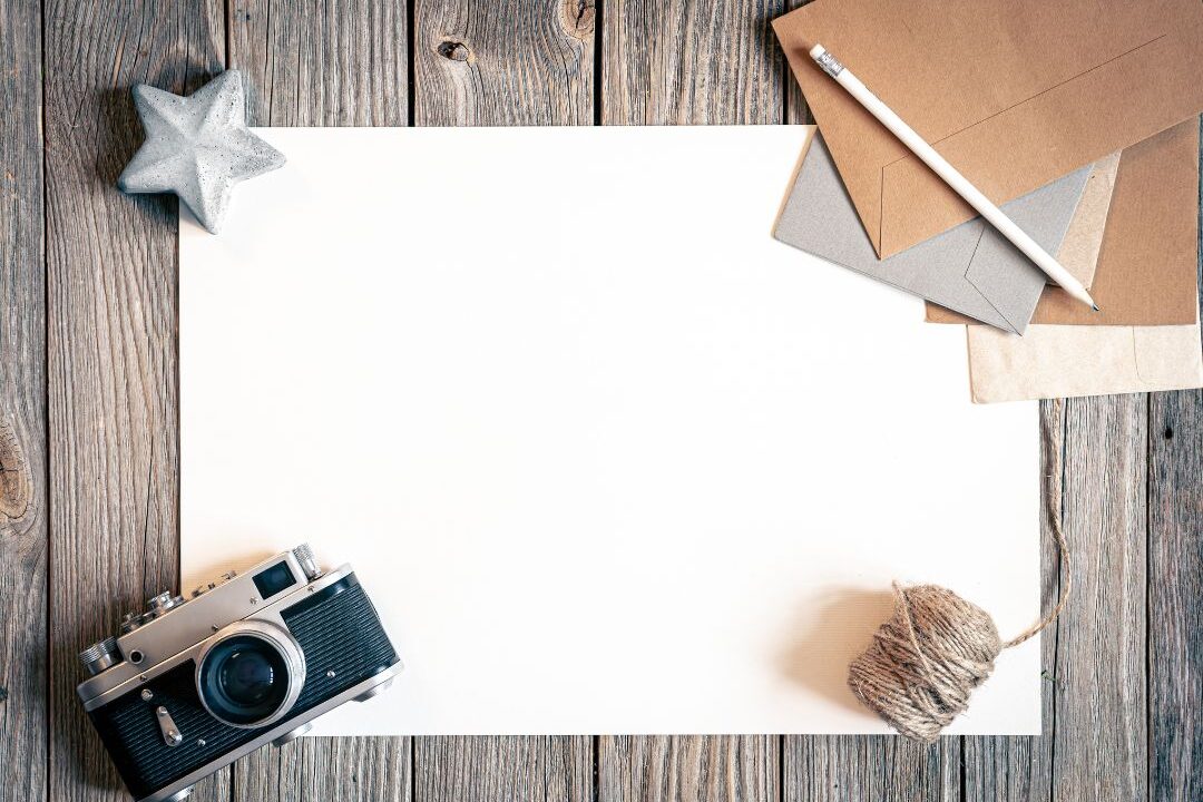 camera and styling props arranged neatly on a white wooden surface