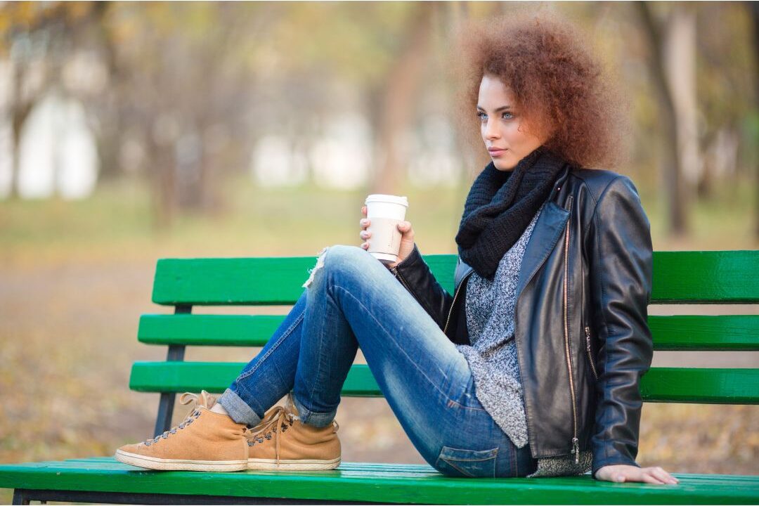 woman sitting alone on a park bench drinking tea peaceful environment