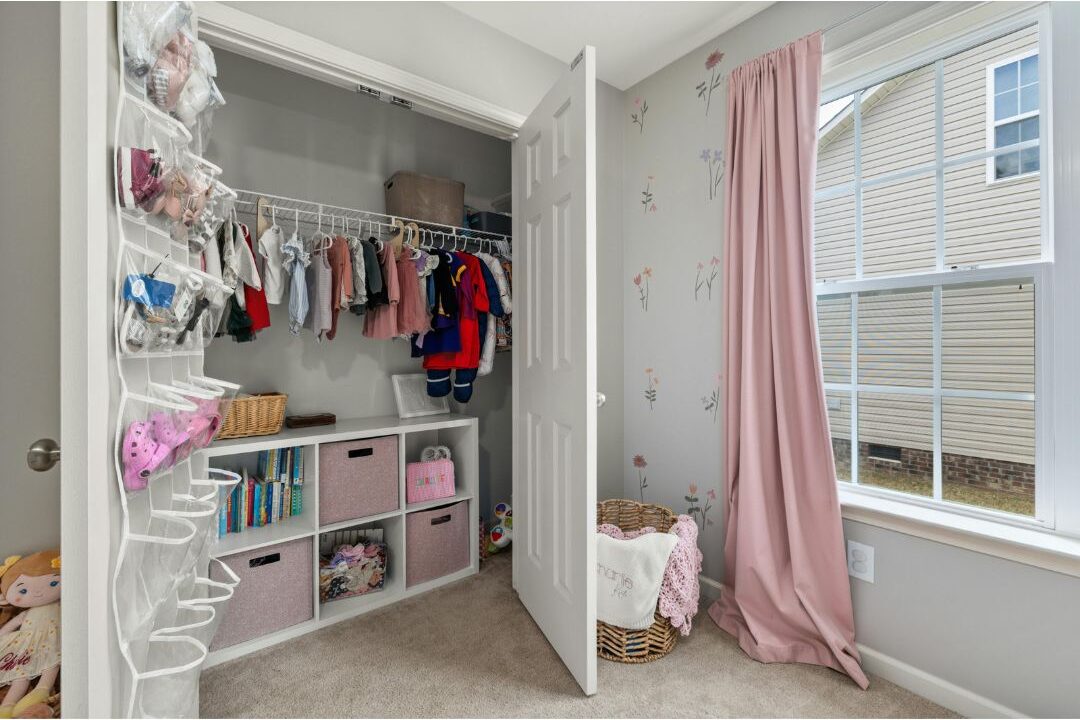 organized children closet with simple clothes and shoes