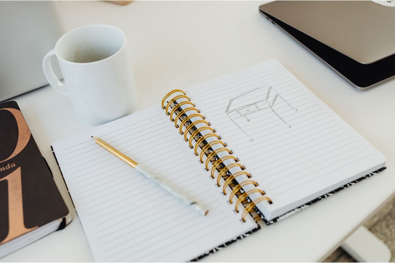 open notebook with written priorities sitting beside mug on table illustrating morning systems