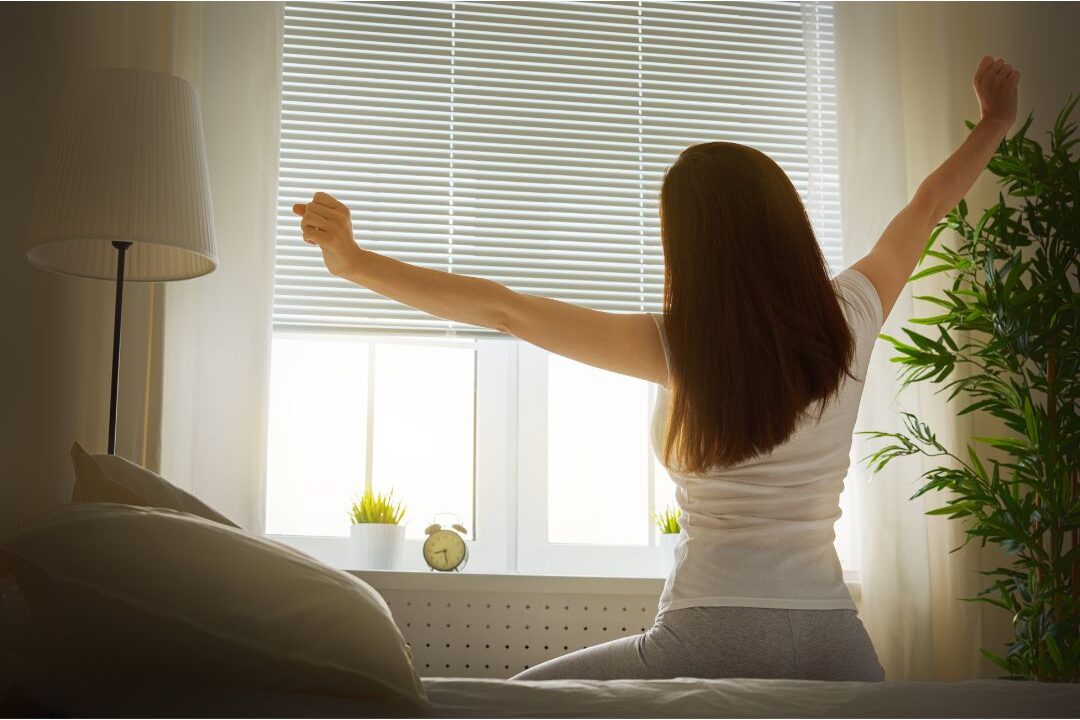 woman waking up naturally in morning light looking peaceful