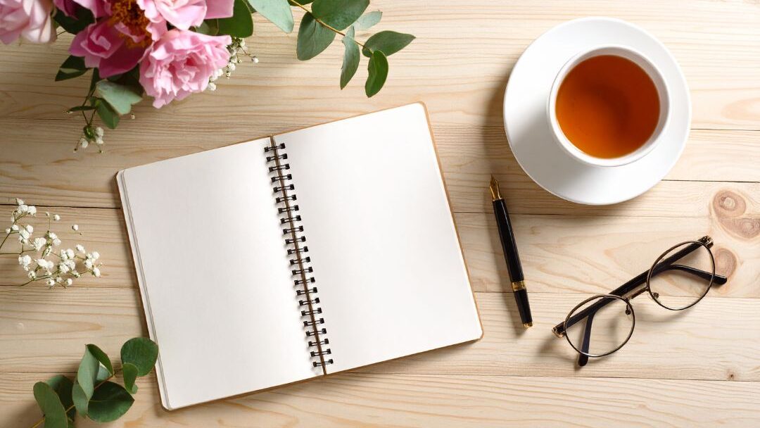 warm cup of tea beside open journal on sunny table representing soft energy management