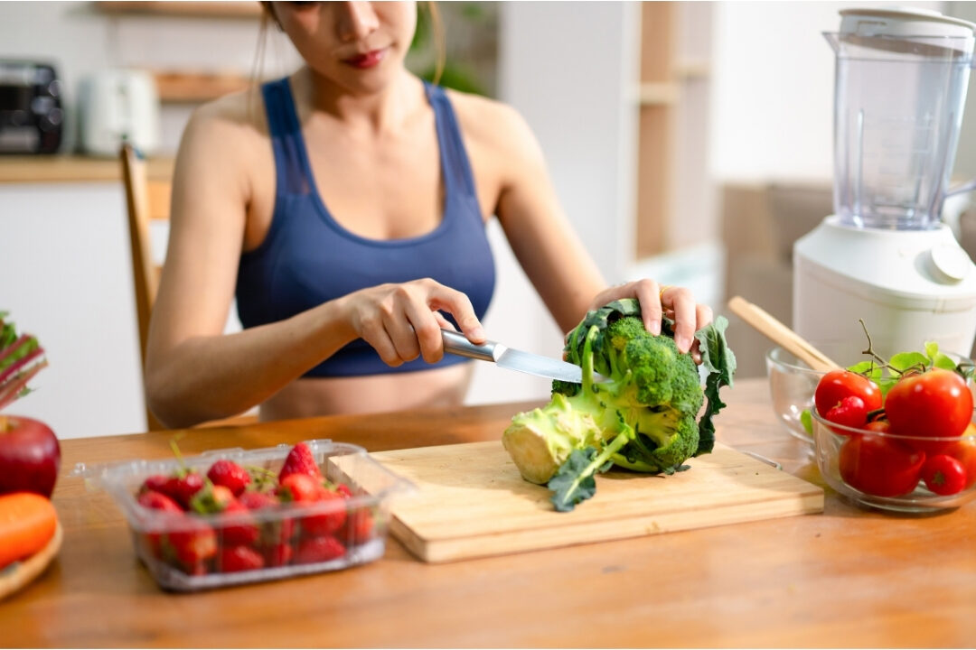 woman happily preparing fresh meal with herbs in sunlit kitchen enjoying intentional hobbies