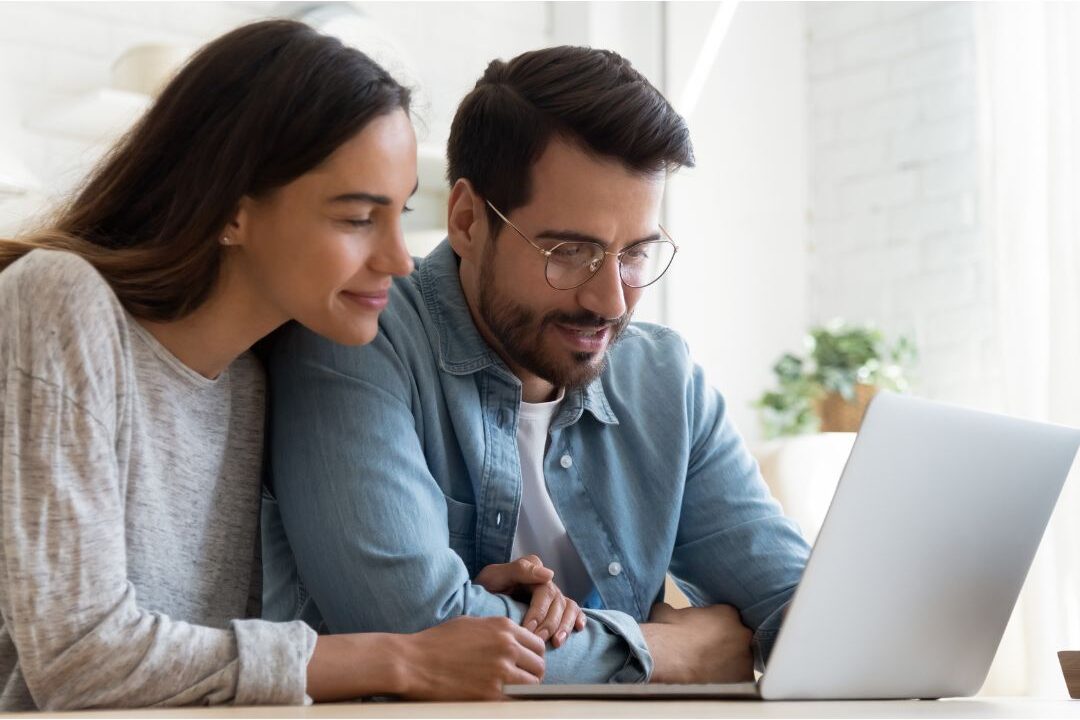 couple looking at a laptop screen together planning family finances showing ways to fix money mistakes stay-at-home moms make