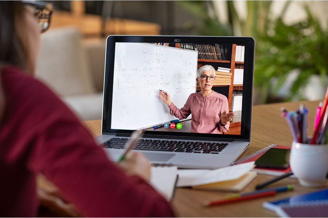 woman taking an online course on her laptop with coffee at home