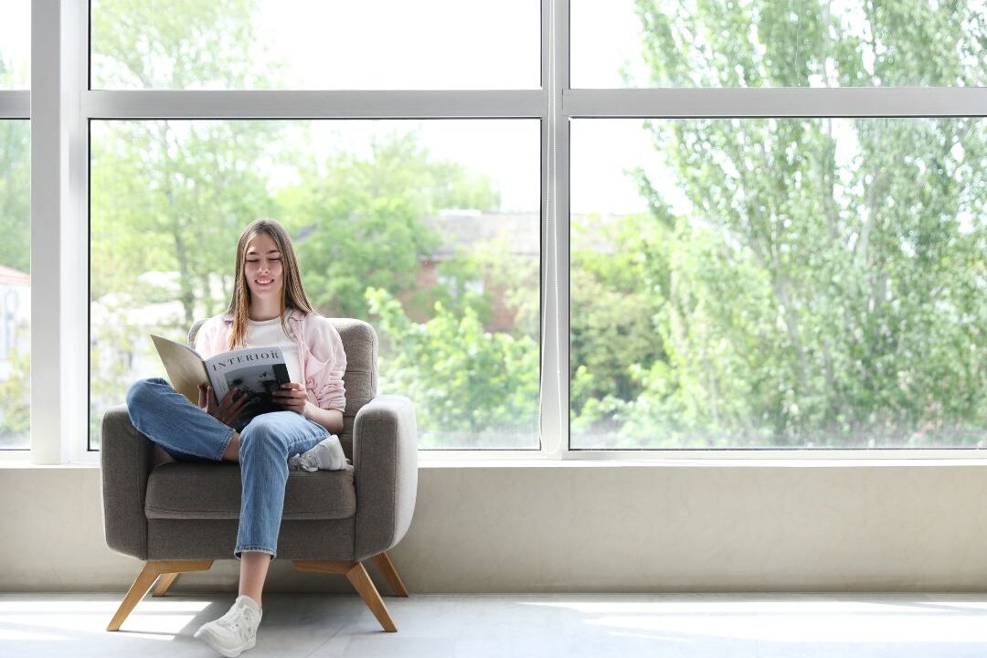 woman relaxing on comfortable armchair reading book near sunny window breaking schedule misalignment time-wasting habits