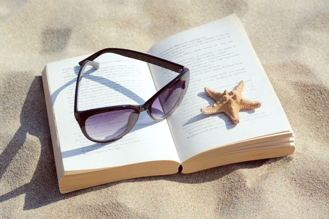 tortoiseshell sunglasses resting on open book in sunny room showing classic eyewear