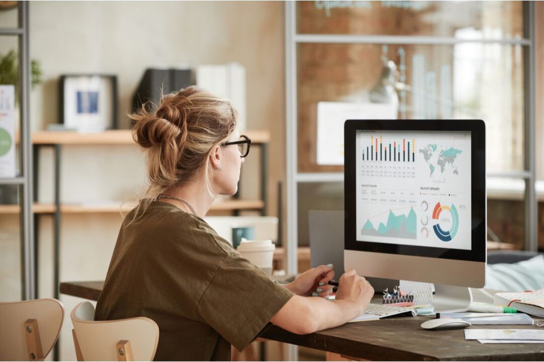 woman examining data graphs on a computer monitor to avoid the biggest blogging mistakes beginners make