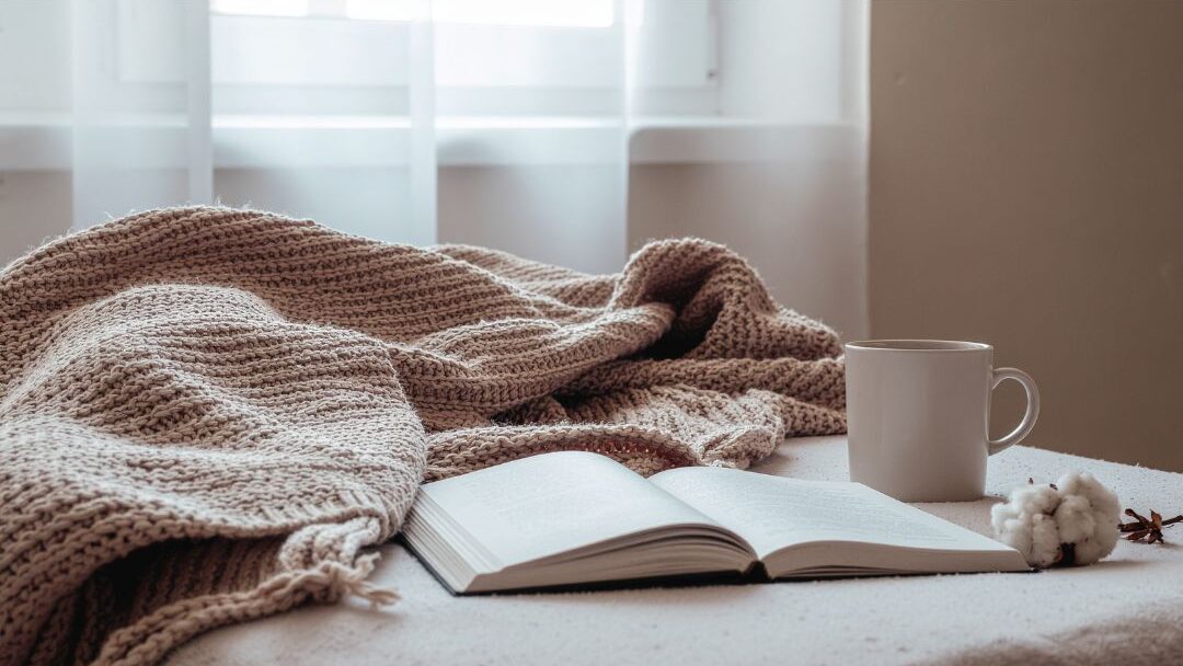 cozy reading nook with an open book and notebook on a table highlighting passive income streams that actually still work