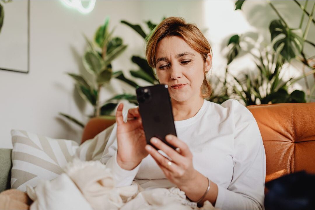woman smiling calmly looking at her phone demonstrating practical ways to feel like yourself again