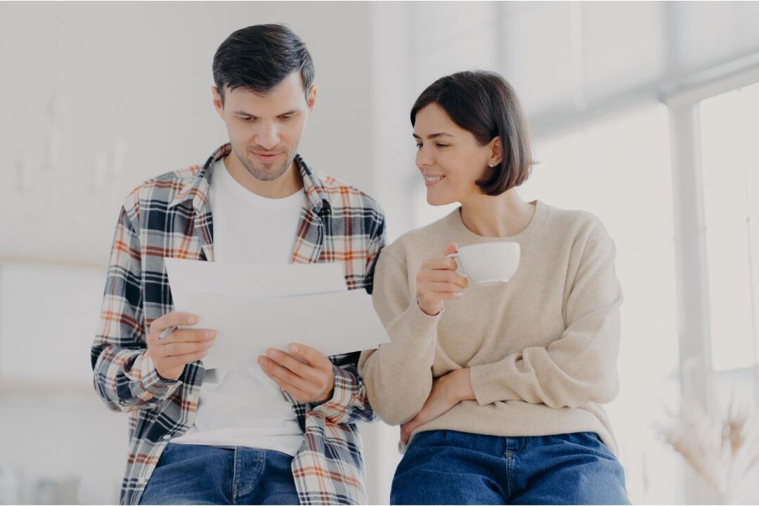 couple sitting at a dining table reviewing family paperwork together calmly