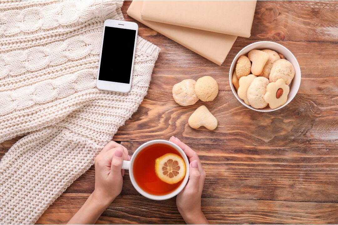 woman placing phone down on wooden table to drink tea showing digital boundary