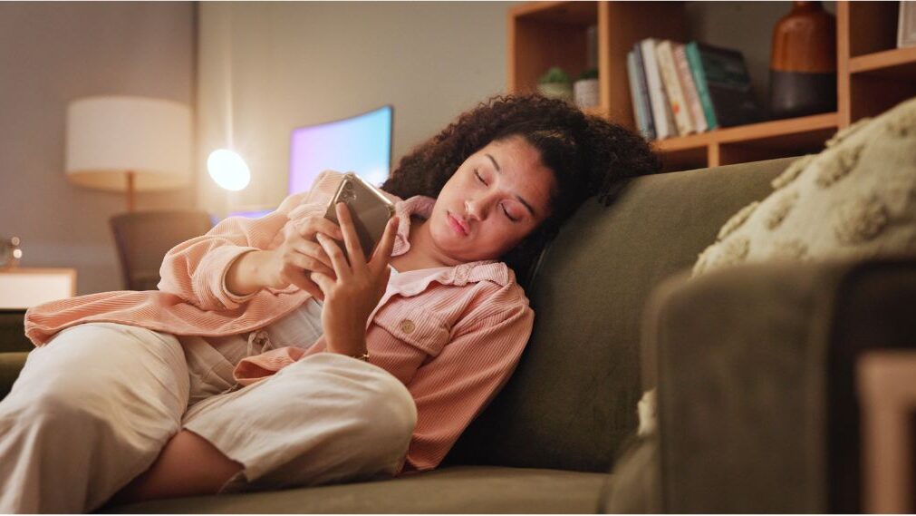 woman scrolling through her phone with a tired expression reviewing social media business promises