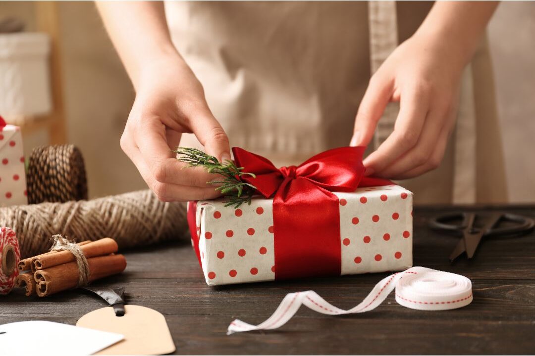 woman signing a gift card on a wooden table identifying the hidden expenses quietly destroying your budget