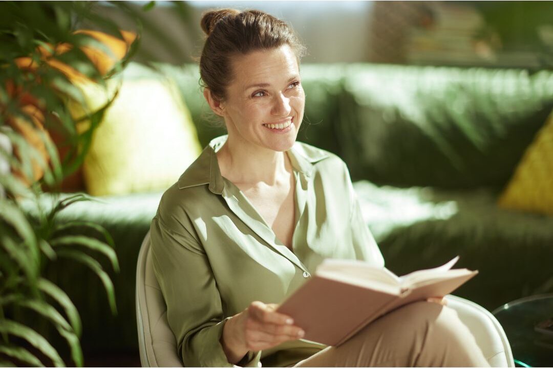 peaceful woman smiling warmly in cozy sunlit living room after stopping time-wasting habits