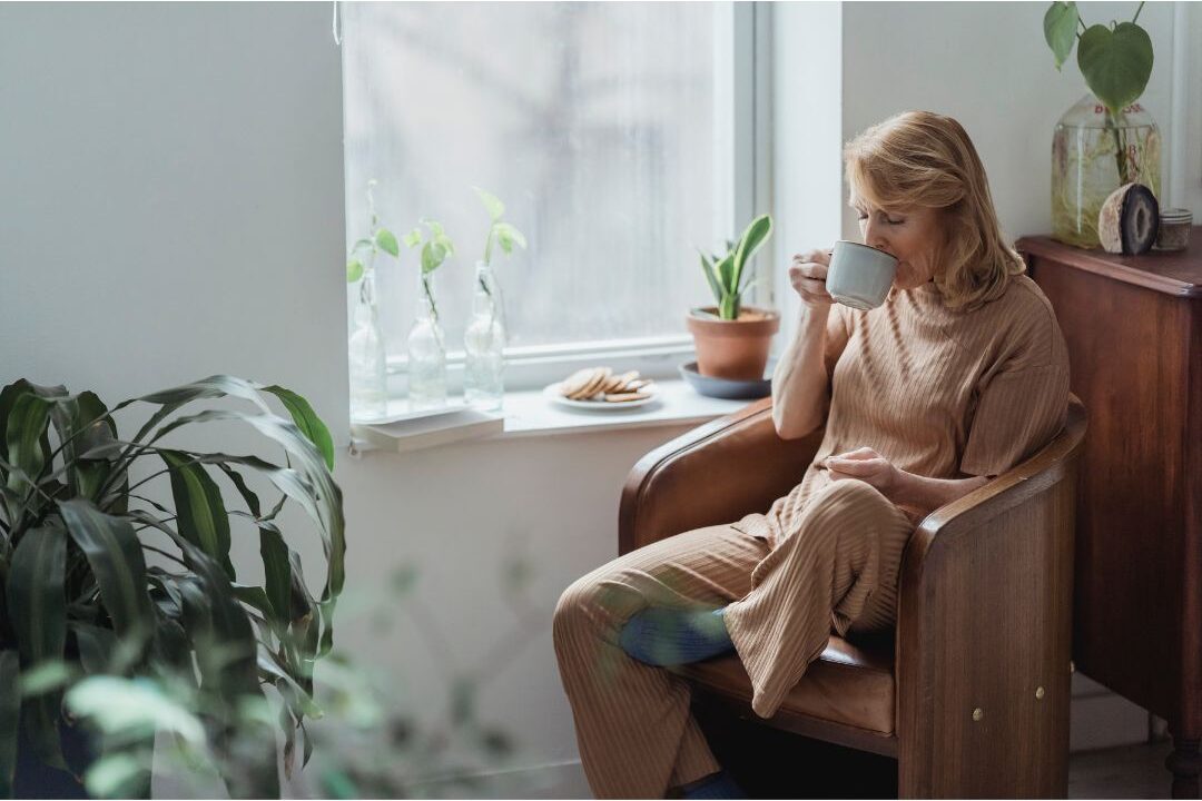peaceful woman relaxing on armchair near window in calm home after eliminating wasting 3 hours every day