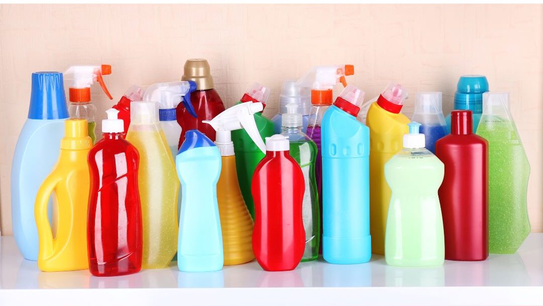 row of plastic cleaning spray bottles on store shelf illustrating items to stop buying