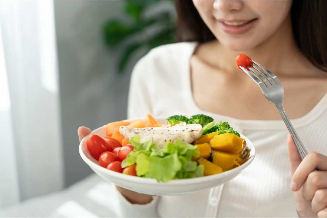 woman enjoying healthy salad lunch at wooden dining table taking a restful lunch break