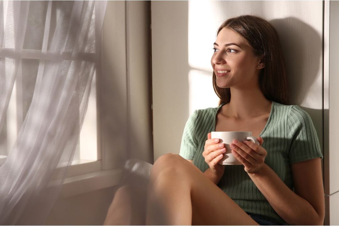 peaceful stay at home mom drinking tea near sunny window showcasing things stay at home moms need to hear