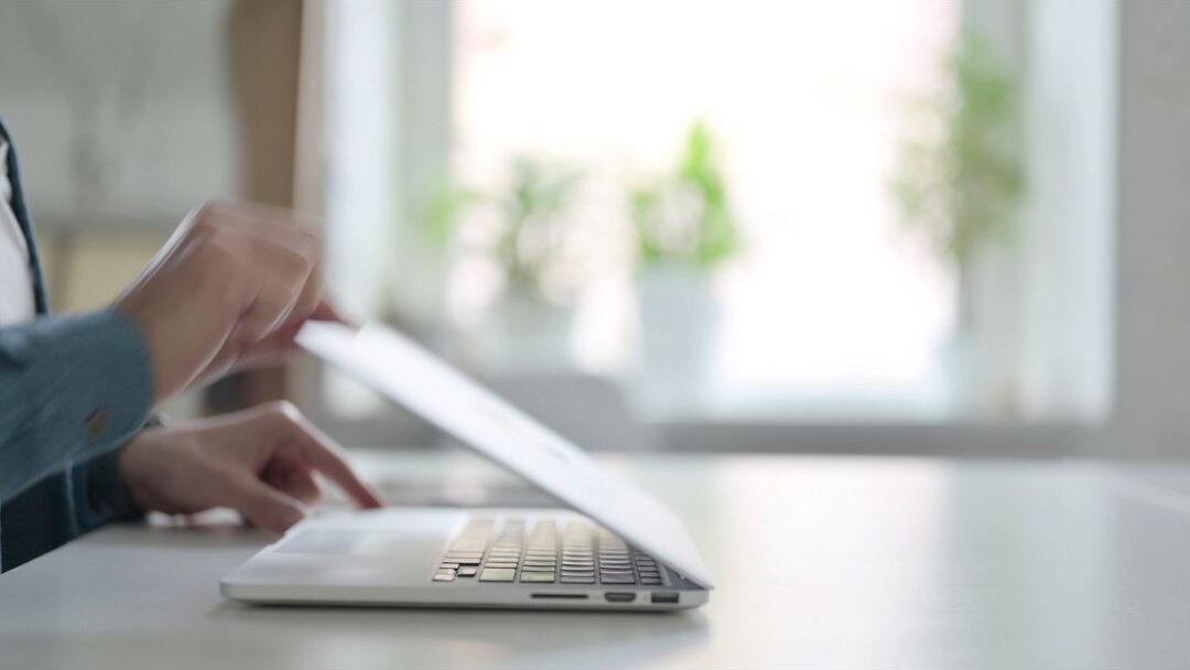 woman closing her laptop at a clean desk with a peaceful expression