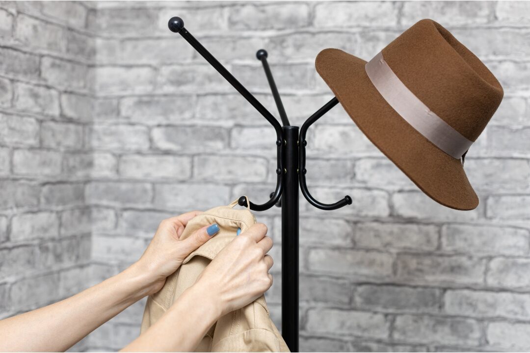 woman hanging coat on entryway hook neatly practicing simple household rules that eliminate daily stress