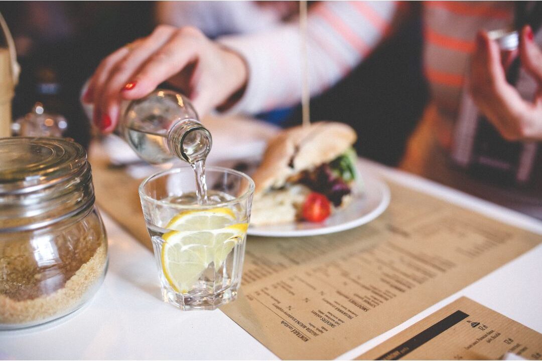 beautifully plated healthy lunch on wooden table with glass of water representing slow living
