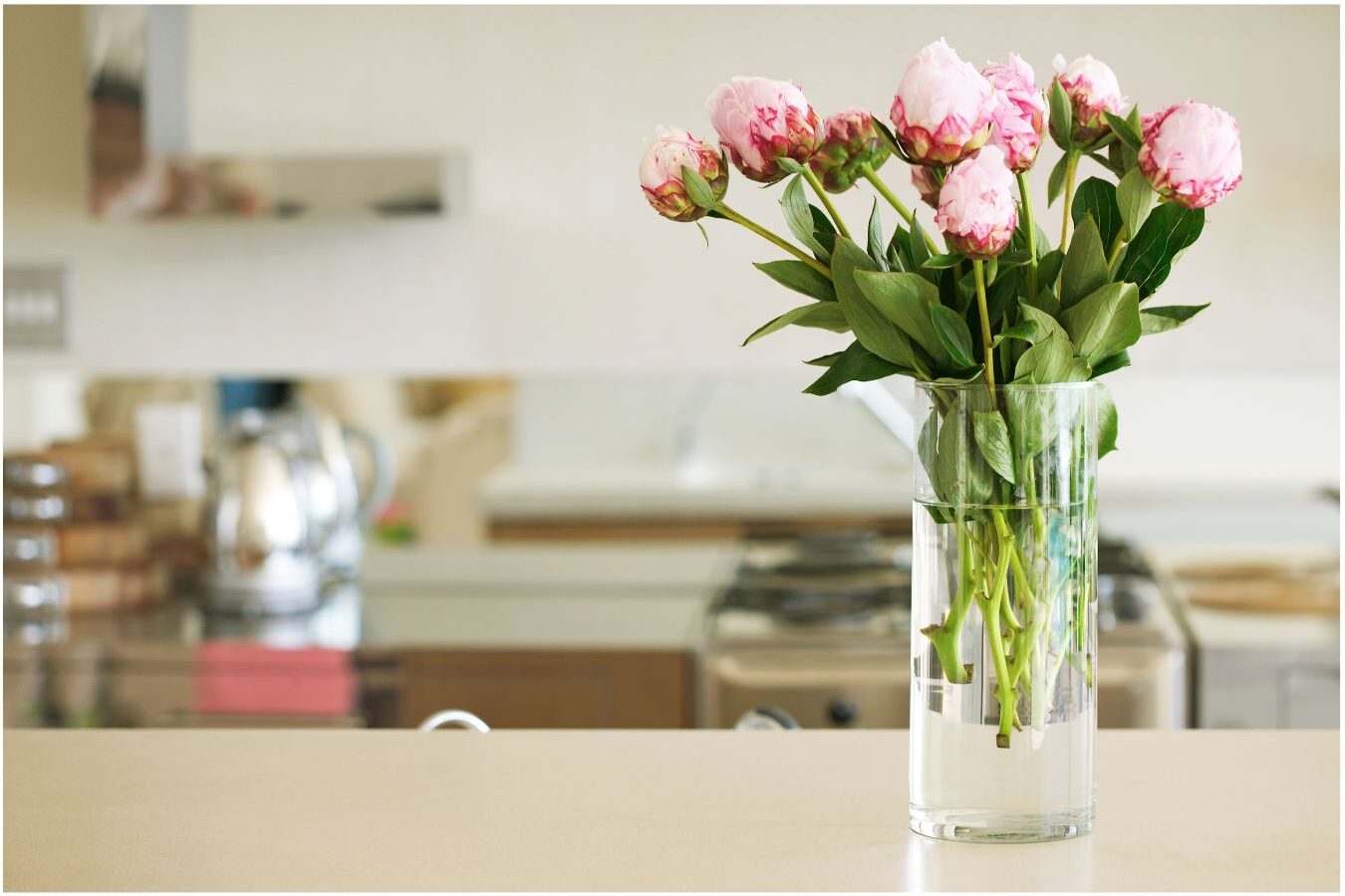 sunlit peaceful kitchen with a vase of fresh flowers on counter demonstrating how to get more done before breakfast