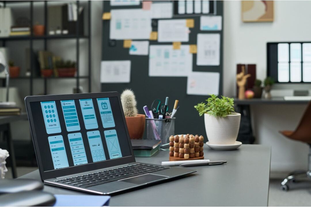 laptop screen displaying a graphic design interface on a clean desk