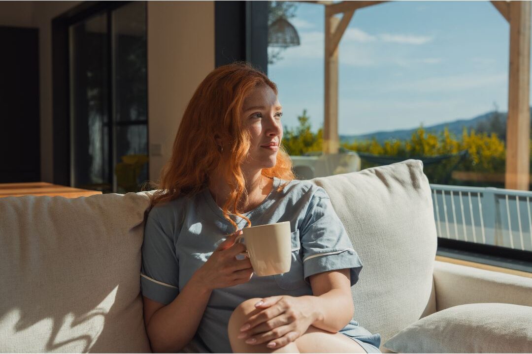 thoughtful woman sitting near sunny window discovering ways to feel like yourself again