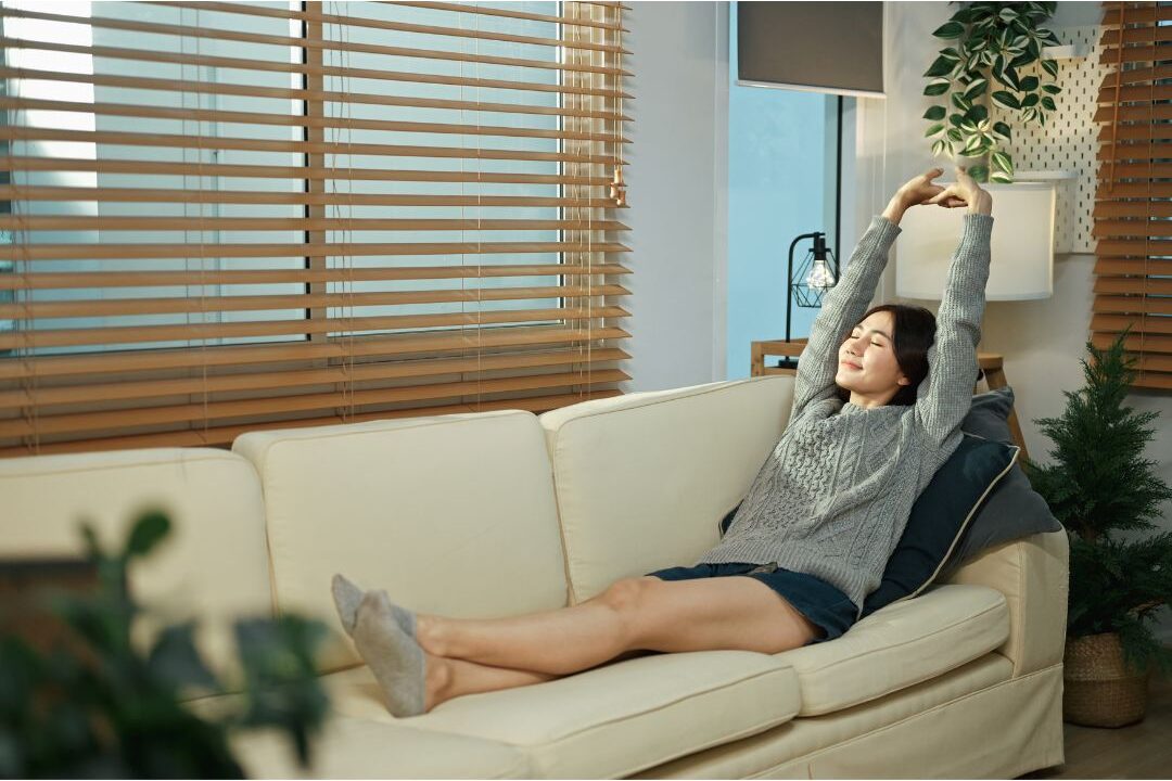 peaceful woman smiling warmly in a comfortable living room embracing rested living