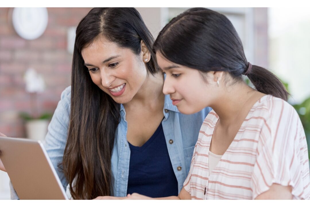 mother and teenage daughter discussing schedule at wall command station adapting family system