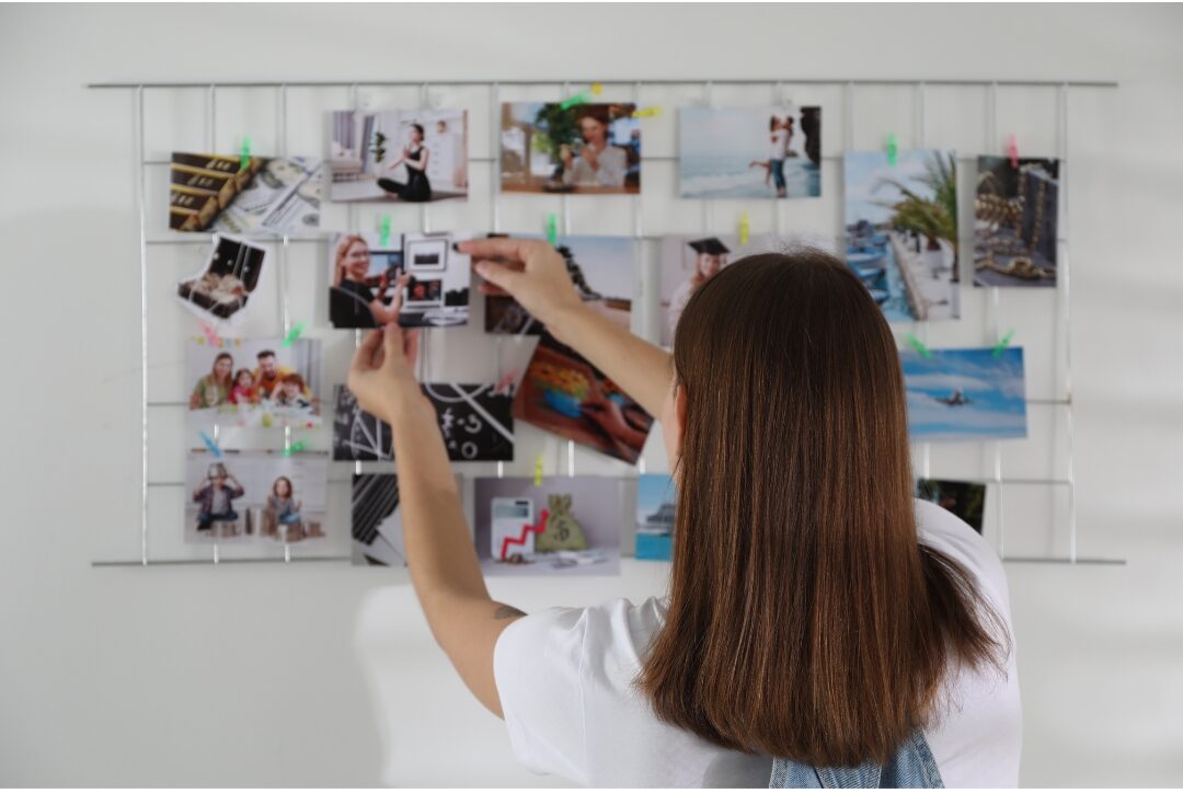 woman sitting at clean desk looking at vision board thoughtfully aligning values