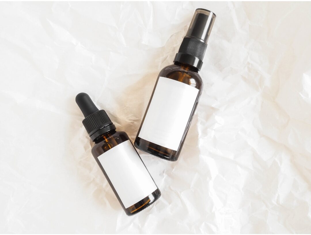 amber glass spray bottles with clean labels on wooden kitchen counter discovering 30 tiny luxuries every woman deserves