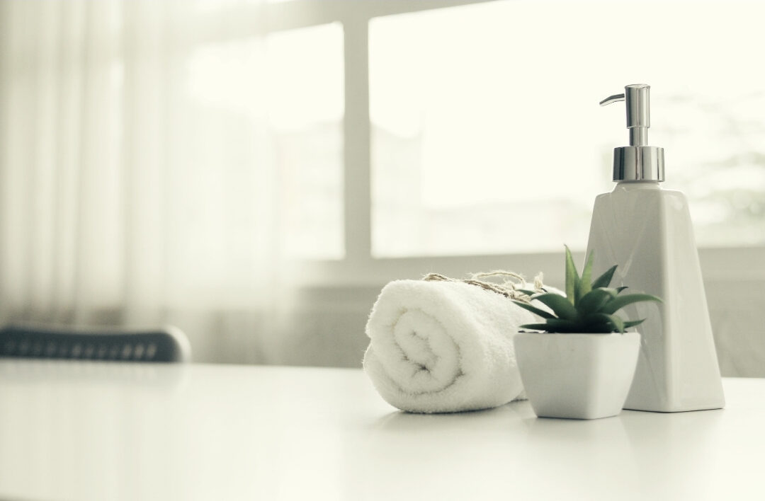 clean white bathroom counter with a simple soap dispenser working through 101 things to declutter this weekend