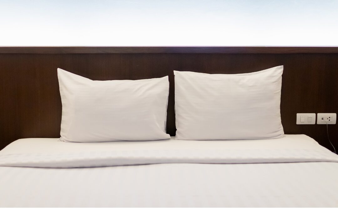 neatly made bed with crisp white washed linen duvet cover listing 75 things every elegant home has
