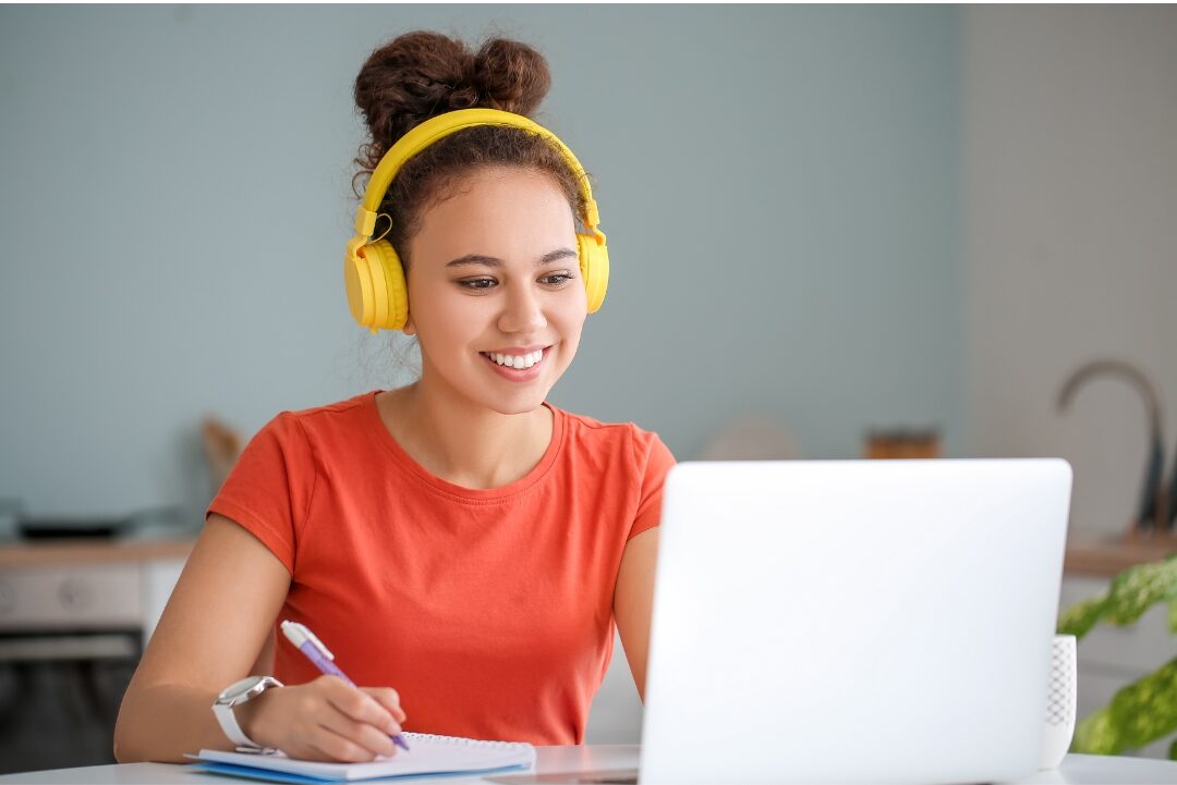 woman studying online course on computer with notebook ready investing in personal development