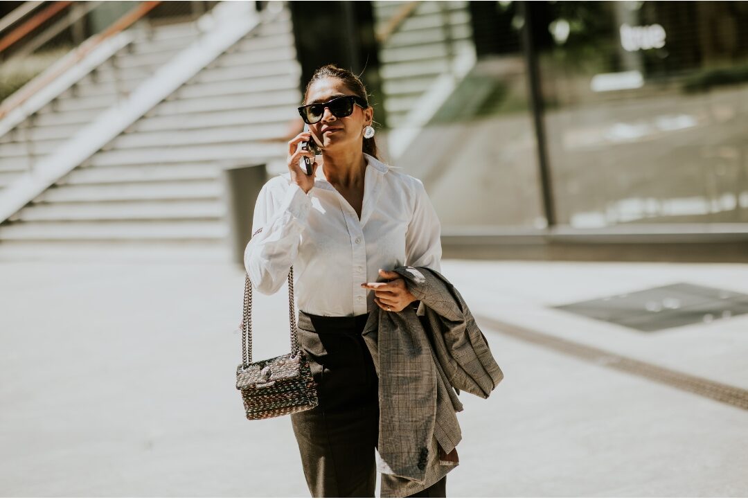 woman walking confidently outdoors in city setting with bright posture letting go of external judgment and beliefs that keep moms playing small