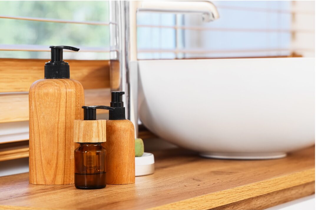 amber glass bottle with pump lotion beside ceramic bathroom sink