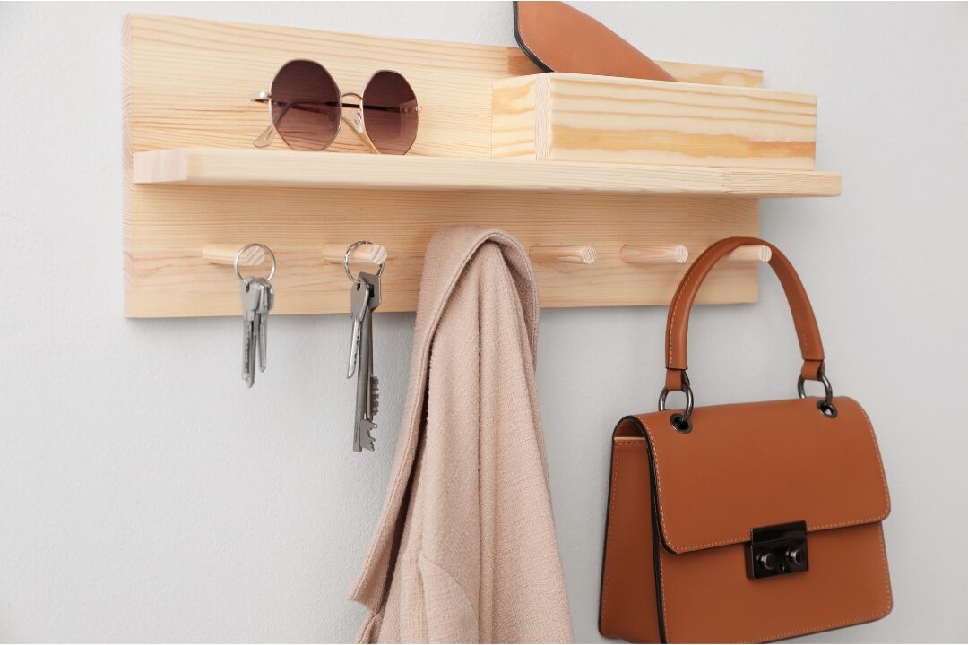 wooden wall key holder with coat hooks holding keys and sunglasses organizing daily entry items