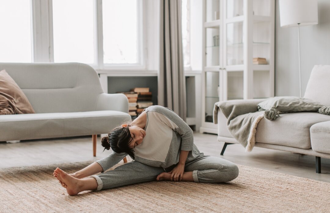 woman stretching gently on soft rug in quiet sunny room practicing mindful vitality
